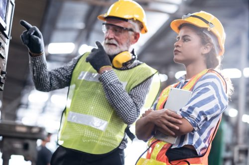 Industrial Engineers in Hard Hats.Work at the Heavy Industry Manufacturing Factory.industrial worker indoors in factory.aged man working in an industrial factory.