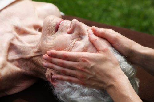 "Beautiful elderly woman receiving a gentle healing massage.Shot with Canon 5D2, processed with slight color saturation added."